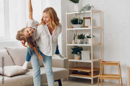 Joyful mother and daughter playing together in a cozy living room, enjoying quality family time and laughter