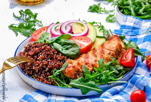 Harvard plate with chicken as protein, quinoa as carbohydrates, vegetable and arugula as fiber, avocado as healthy fats on white background, top view photo