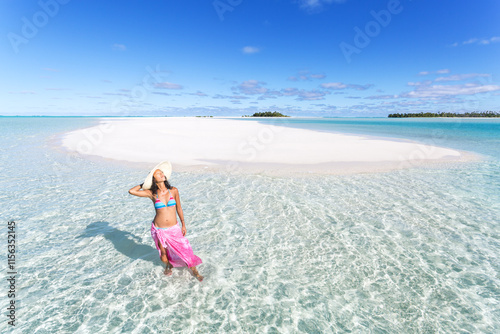 Asian woman standing in the clear water on a sandbar, Honeymoon Island, Aitutaki, Cook Islands photo