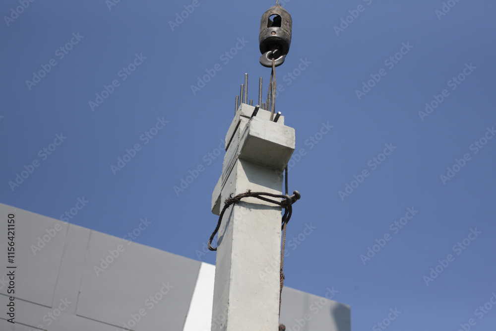 Construction Workers Securing Concrete Column with Wire Rope Sling and Safety Gear Construction Workers Securing Concrete Column with Wire Rope Sling and Safety Gear