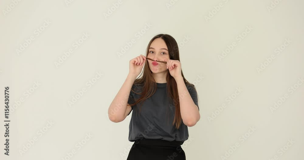Young woman shows off her moustache with hair Young woman shows off her moustache with hair