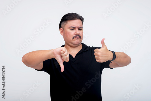 Foto A stocky middle aged man with a mustache with mixed feelings unsure whether to gives a thumbs up or thumbs down