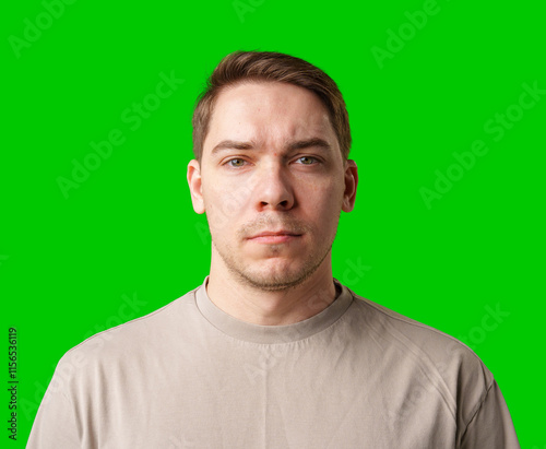 A man standing against a vibrant green backdrop with neutral expression