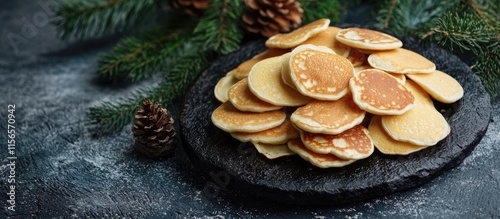 Homemade mini pancakes garnished with pine leaves served on a cast iron stone ideal for cozy breakfast and brunch presentations photo