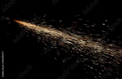 A long stream of sparks is shooting out of a black background