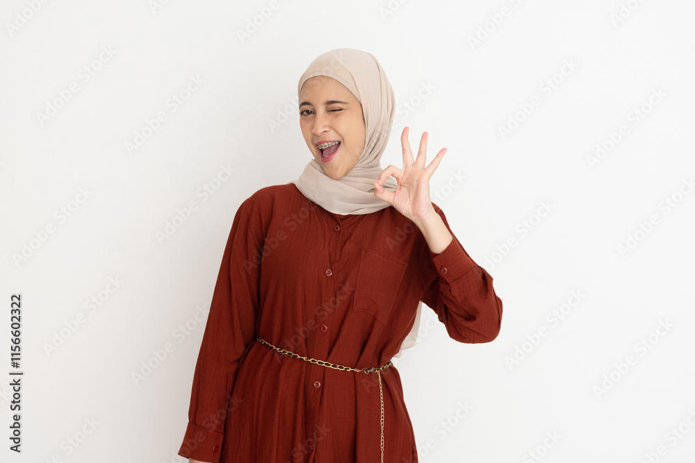 Beautiful smiling Asian woman showing okay gesture demonstrates symbol of approval isolated over white background Beautiful smiling Asian woman showing okay gesture demonstrates symbol of approval isolated over white background