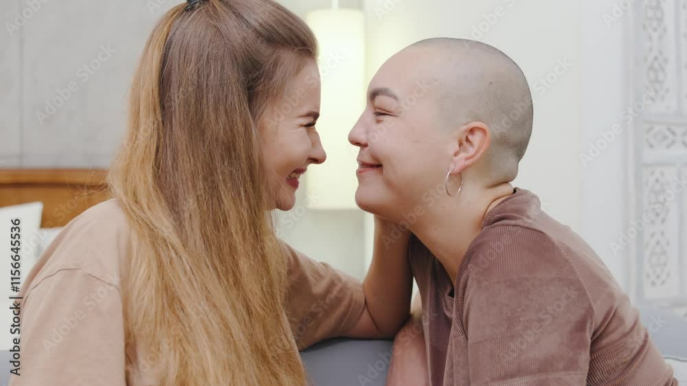 Two lesbian women sit on the couch at home, embracing lovingly, enjoying a tender and emotional moment in their relationship. Two lesbian women sit on the couch at home, embracing lovingly, enjoying a tender and emotional moment in their relationship.