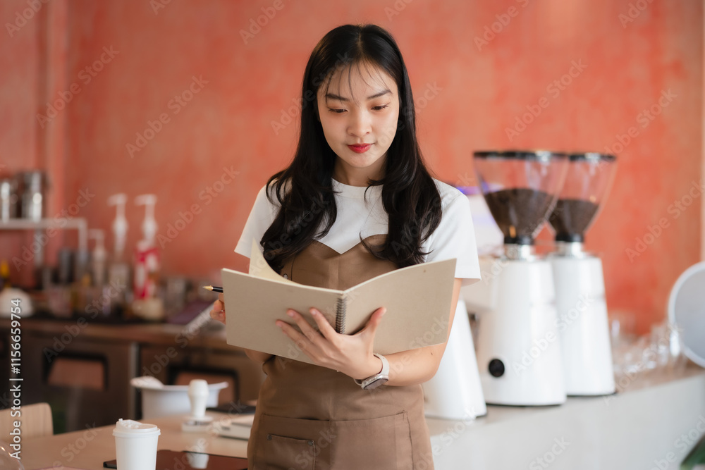 Asian female barista wear apron at counter bar, cafe service concept, owner business start up. Asian female barista wear apron at counter bar, cafe service concept, owner business start up.