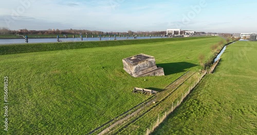 view of the historic bunker Vreeswijk Oost in grassland with a road and river in the background photo