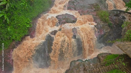 Rainy season causes flash floods as rising water rushes down rocky terrain in aerial view