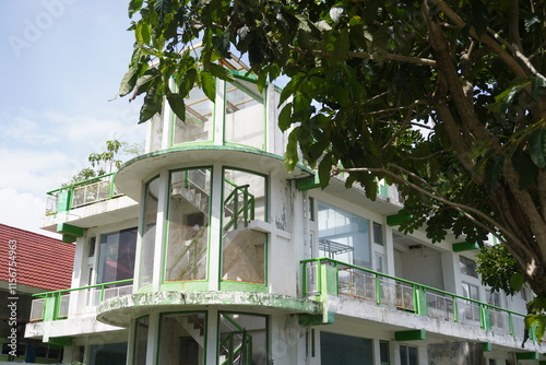 Abandoned glass-fronted multi-storey building with trees photo