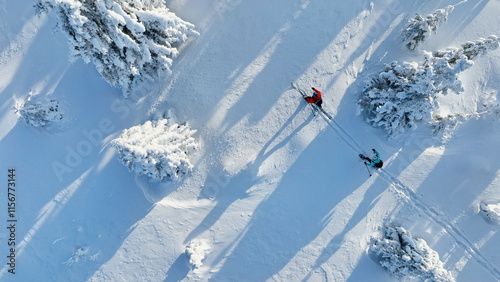 Aerial view of ski touring man and woman with snow shoes crossing winter mountains, fresh snow.