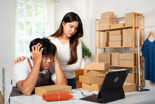 young asian man working at small business ecommerce using laptop stressed and frustrated with hand on head, worries.