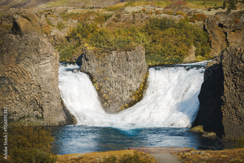 Hjálparfoss Waterfall in Þjórsárdalur is a double-armed waterfall flowing through basalt columns in a lava field near Hekla volcano, Iceland. photo