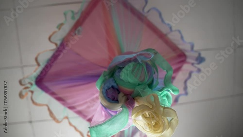 Vividly designed mosquito net with various colors attached to the ceiling, showcasing aesthetic utility and artistic design.