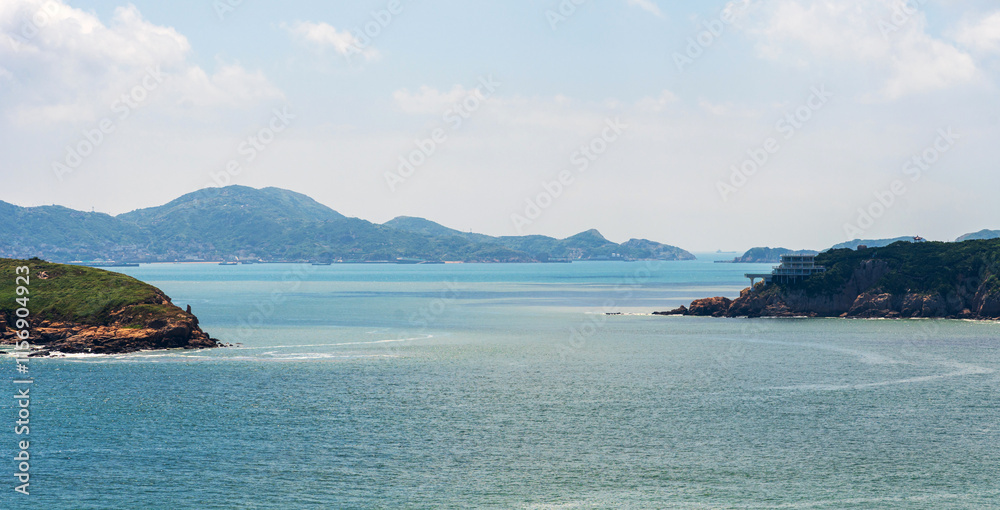 Tranquil Coastal Landscape with Distant Islands and Clear Blue Sky Tranquil Coastal Landscape with Distant Islands and Clear Blue Sky