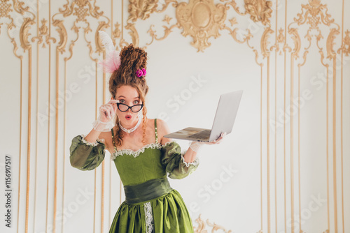 Young woman in period costume holding a laptop, blending past and modern life