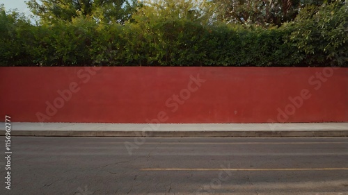 Clean Roadside Landscape: A red wall with grass along a road 