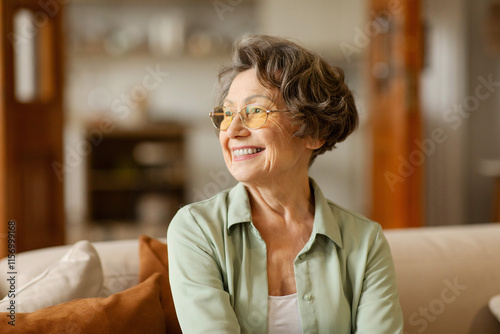 Fotografie Happy dreamy senior woman in glasses look aside into distance deep in pleasant m