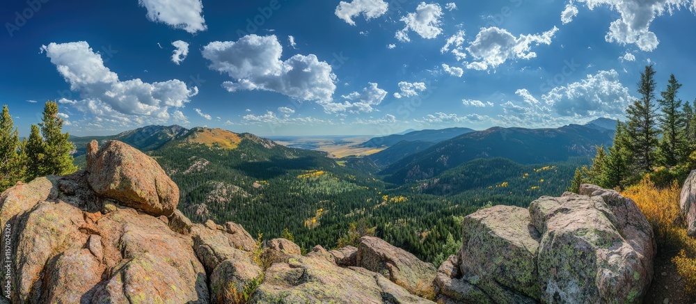 Obraz premium Panoramic view from a mountain peak showcasing lush valleys and dramatic sky with clouds in a vibrant natural landscape.
