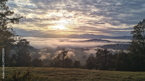 Morning sun illuminating fog-covered mountains under a sky filled with clouds and soft light creating a serene landscape. photo