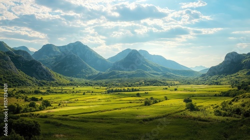 Vast karstic landscape featuring lush green valleys and majestic mountains under a vibrant blue sky with scattered clouds