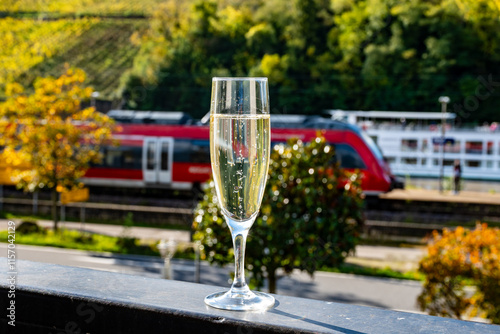 Tasting sparkling white wine, traditional champagne method making of cremant in caves on Moselle river valley in Luxembourg, glasses of wine and view on terraced vineyards photo