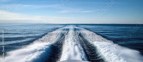 Boat wake on calm water with blue skies showcasing speed and movement of the vessel creating dynamic waves in the ocean scenery.