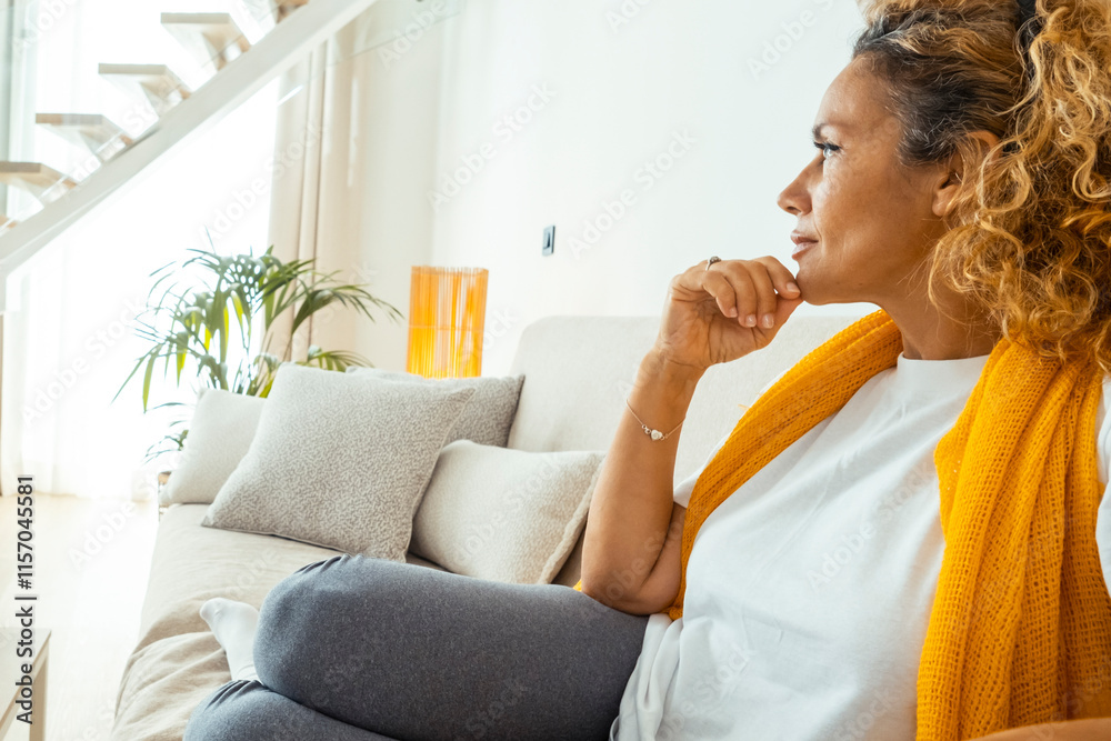 A fifty-year-old woman relaxing alone in her living room at night, sitting on her sofa in silence, contemplating her thoughts, and embracing a mindful moment of introspection and personal growth A fifty-year-old woman relaxing alone in her living room at night, sitting on her sofa in silence, contemplating her thoughts, and embracing a mindful moment of introspection and personal growth