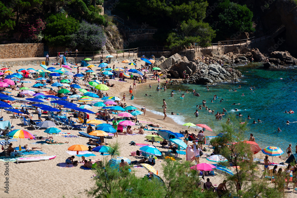 Tourists relaxing on the picturesque beach of aiguablava, costa brava, spain