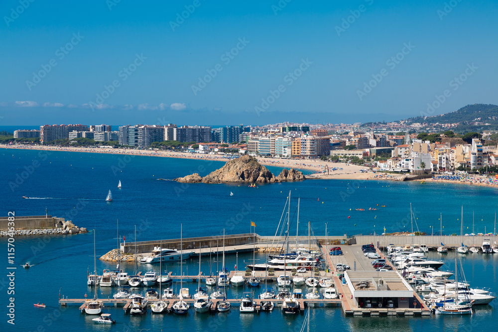 Blanes cityscape with harbor, beach and sa palomera rock in summertime