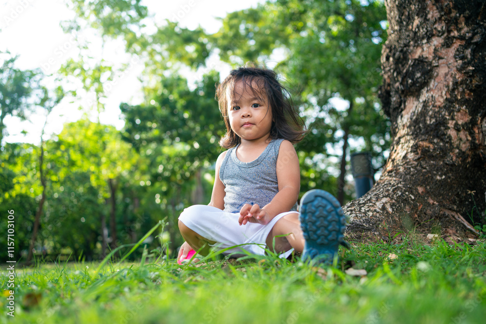 Adorable little toddler girl on green meadow grass tree park Adorable little toddler girl on green meadow grass tree park