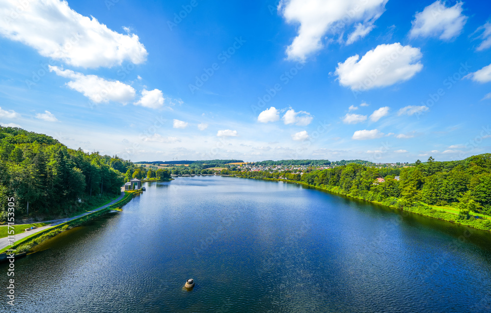 View from the historic dam wall at Möhnesee. Möhne Dam with the surrounding nature on the lake.
View from the historic dam wall at Möhnesee. Möhne Dam with the surrounding nature on the lake.