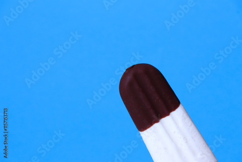 ice cream in chocolate glaze close-up with condensate and icing frost on a summer blue sky background. Ice cream texture.