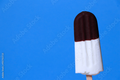 ice cream in chocolate glaze close-up with condensate and icing frost on a summer blue sky background. Ice cream texture.