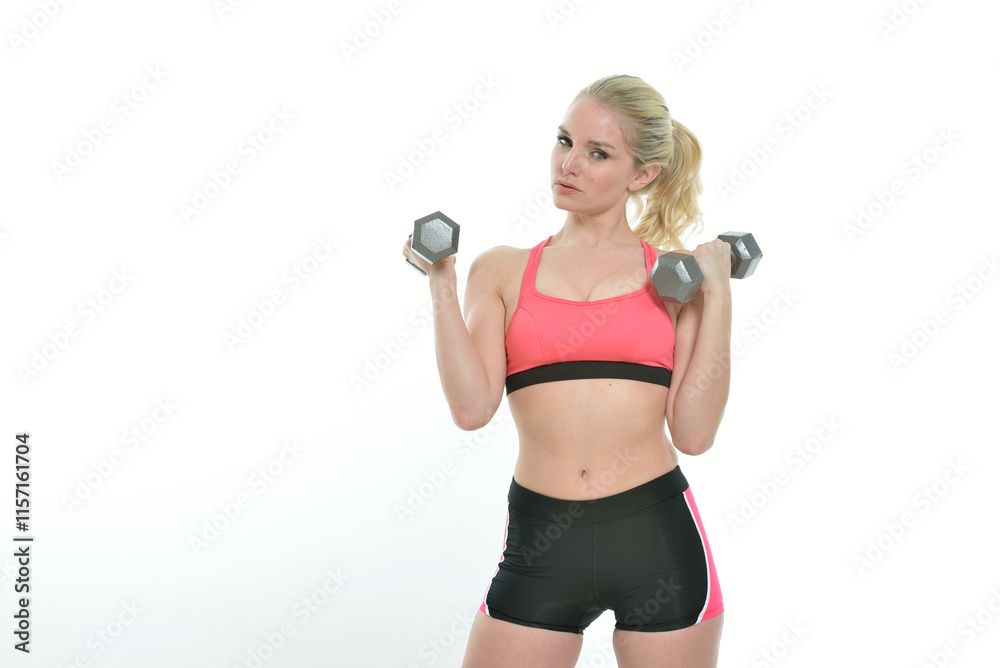 Sexy young Caucasian woman - fitness model - posing in lycra shorts and sports bra - lifting dumbbells (weight training) Sexy young Caucasian woman - fitness model - posing in lycra shorts and sports bra - lifting dumbbells (weight training)