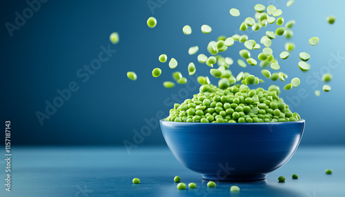 Fresh green peas in a bowl with a blue background.
