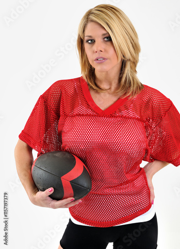 Obraz na plátně Beautiful blonde woman in red mesh football jersey - studio portrait - holding b