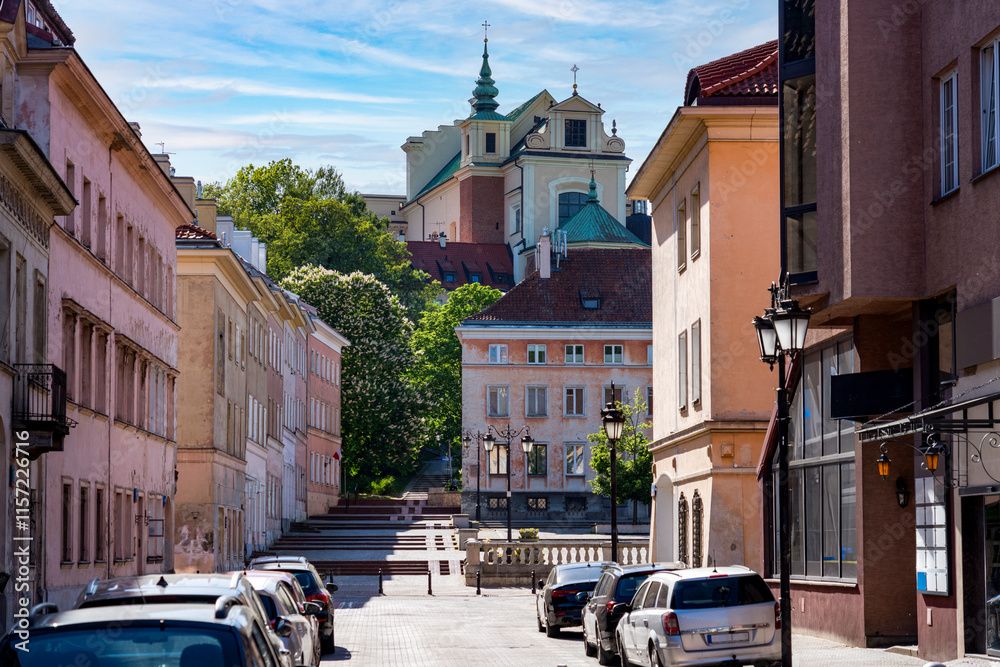 Charming street scene of Warsaw's Old Town with pastel facade buildings and a church in the background