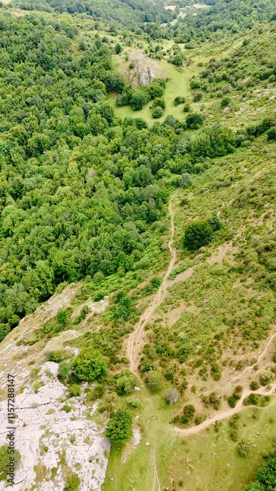 Hikers' trail on the slope of the mountain. Drone approaches the tourist path in the rocky wilderness. Vertical video. Hikers' trail on the slope of the mountain. Drone approaches the tourist path in the rocky wilderness. Vertical video.