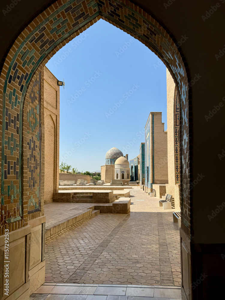 Fototapeta premium Historic Courtyard with Mosaic Arch and Dome under Blue Sky