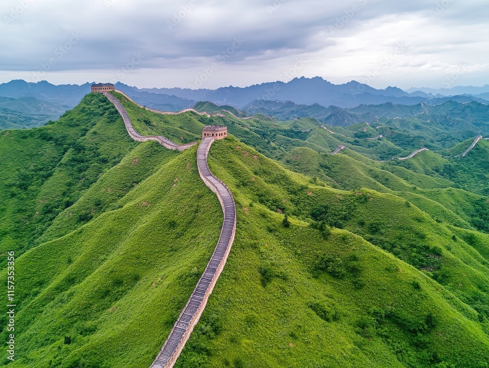 Majestic aerial view of the Great Wall winding through lush green mountains under a dramatic sky. Majestic aerial view of the Great Wall winding through lush green mountains under a dramatic sky.