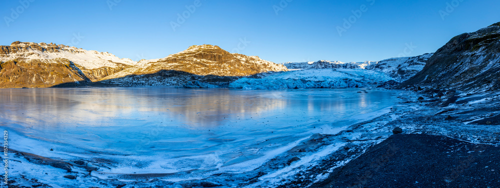 Naklejka premium Panoramic view of Solheimajökull glacier in winter with frozen lake and moody winter light