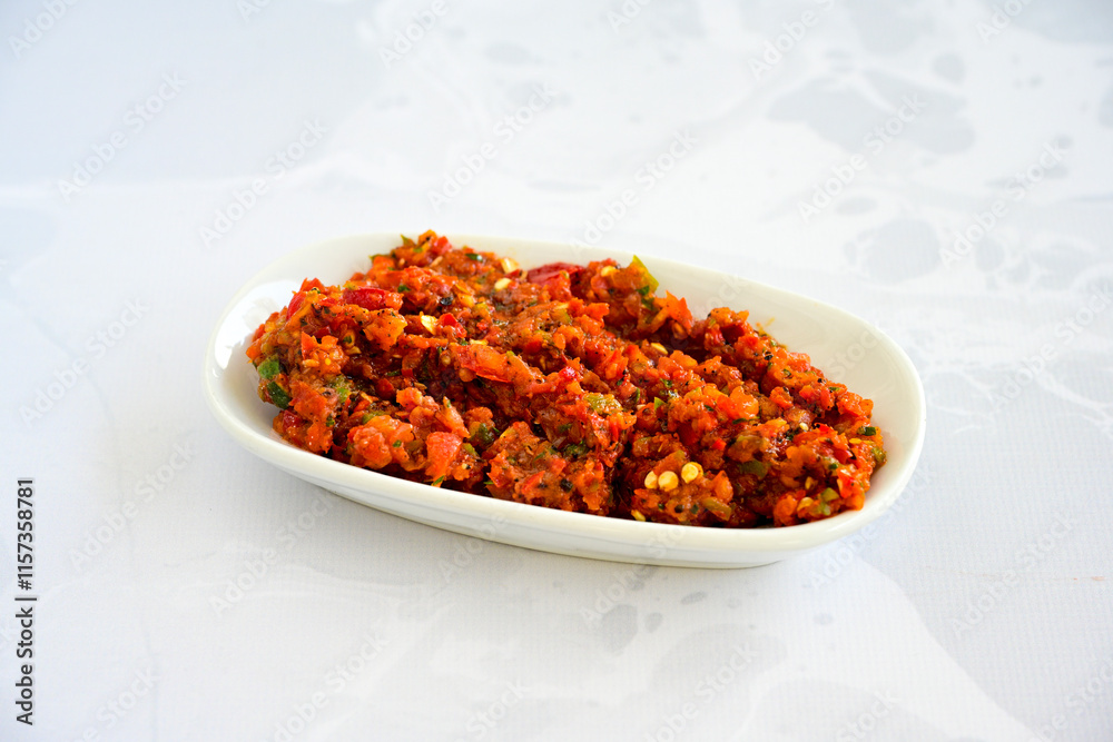 A spicy Turkish appetizer ezme made with tomatoes, bell pepper, parsley, mint, olive oil and hot chili. A kind of adjika. Kahvaltilik acuka, Antep usulu acili ezme. A spicy Turkish appetizer ezme made with tomatoes, bell pepper, parsley, mint, olive oil and hot chili. A kind of adjika. Kahvaltilik acuka, Antep usulu acili ezme.