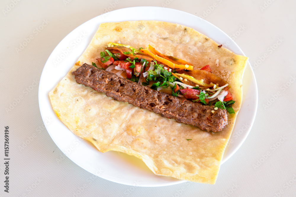 Grilled Turkish Adana, Urfa Kebab with grilled vegetables, onion and rice on plate. Adana durum, Urfa durum . Grilled Turkish Adana, Urfa Kebab with grilled vegetables, onion and rice on plate. Adana durum, Urfa durum .