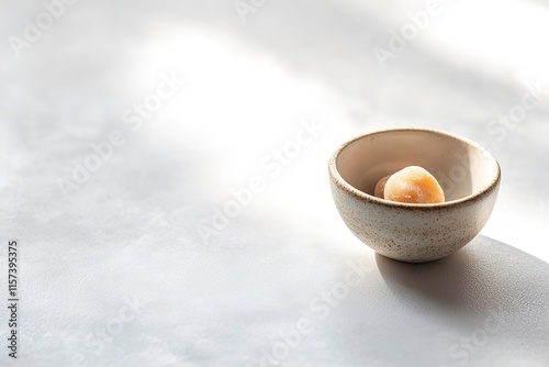 small bowl of middle eastern sweets placed neatly on smooth white ceramic surface under bright diffused light photo