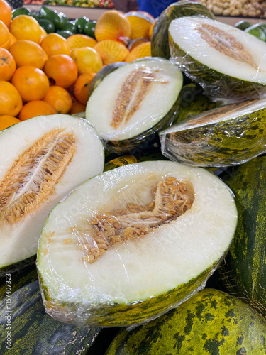 Melão sapo fresco exibido em sacolão, com sua casca texturizada e tonalidade verde-amarelada. Perfeito para destacar frutas saudáveis e deliciosas em ambientes de mercado photo