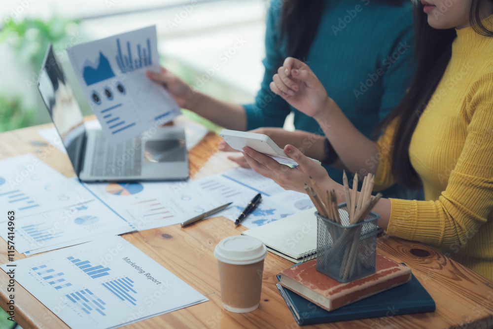 Fototapeta premium Strategic Collaboration: Two businesswomen meticulously analyze financial data, showcasing a synergy of expertise and a shared vision for success. 