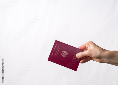 A close-up shot of a hand holding a German passport with a clean white background, symbolizing travel, identity, and international mobility