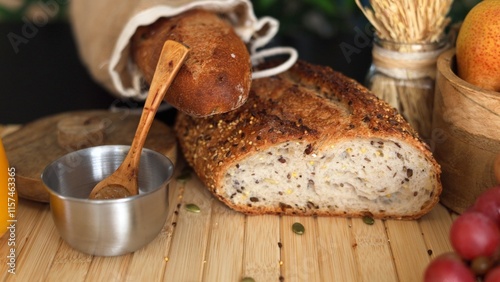 Photos Rustic setup with seeded bread, grapes, pears, wheat stalks, metal bowl with sal
